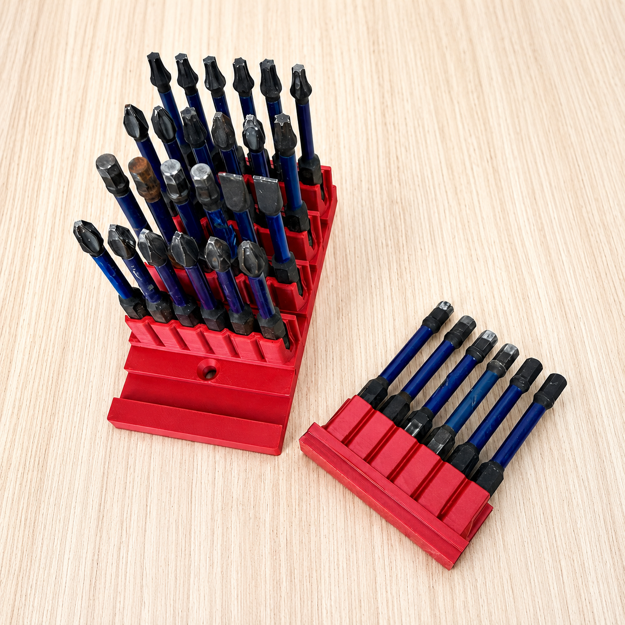 Set of drill bits in red holders on a wooden surface
