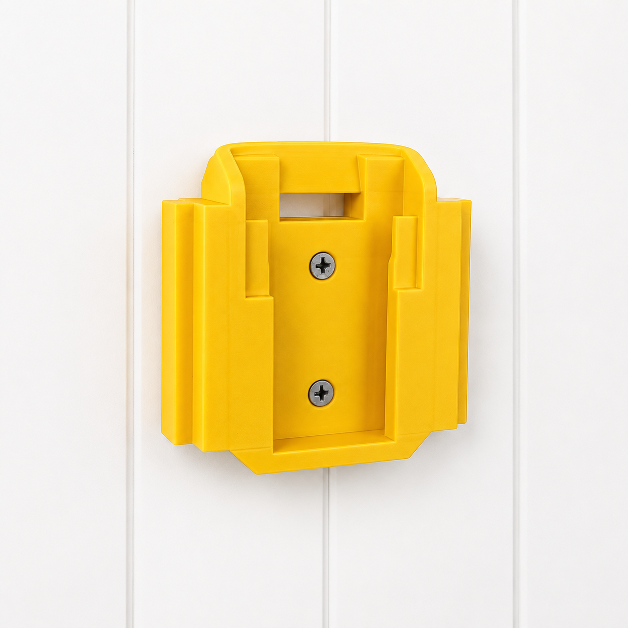 Yellow DeWalt wall-mounted 18v battery holder on a white wooden panel background