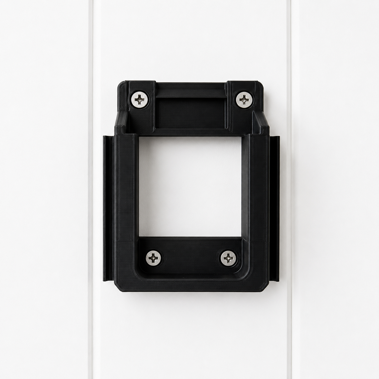 Black Makita 18v battery bracket with screws on a white background