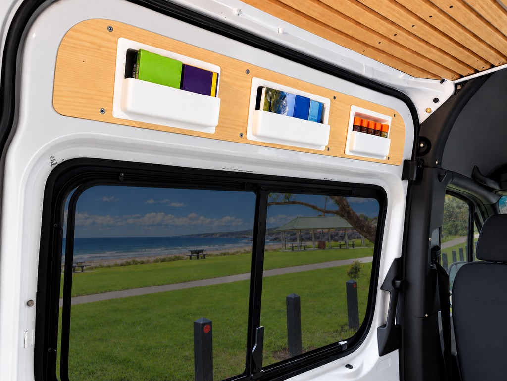 A set of three recessed storages boxes from Barn House Studio, installed in a Mercedes Sprinter on the upper side panel of a white van, with a beach scene visible through the window.