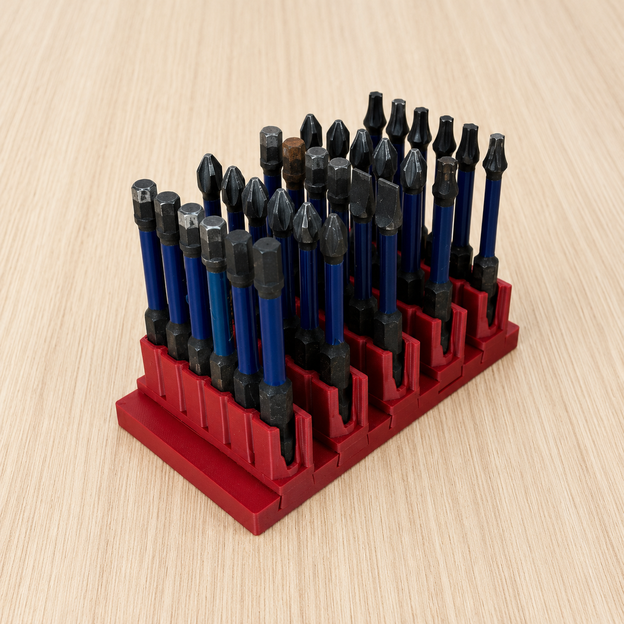 Set of screwdrivers bits in a red bit holder on a wooden surface