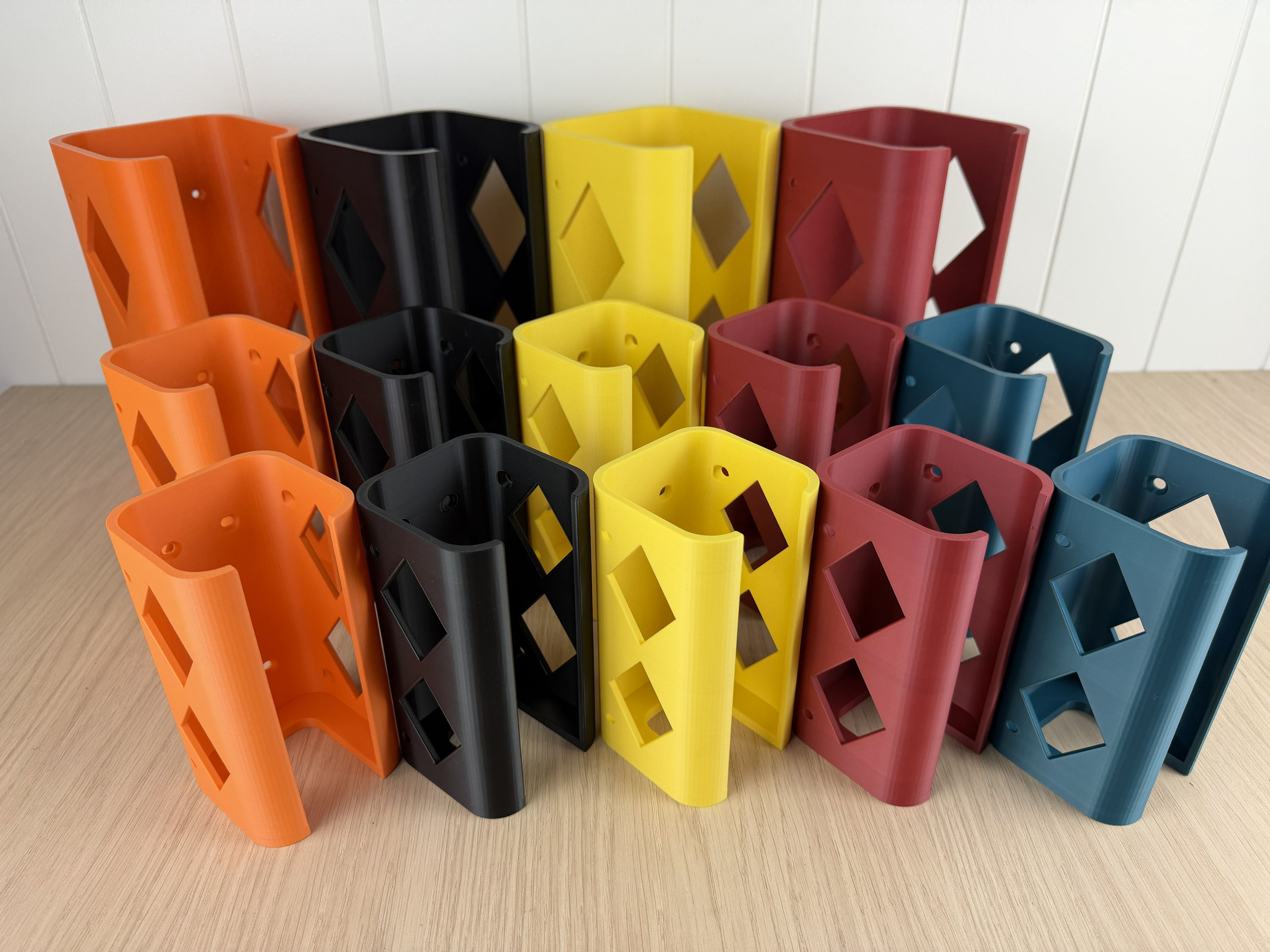 Set of colorful tool holsters on a wooden surface with a white tiled wall background.